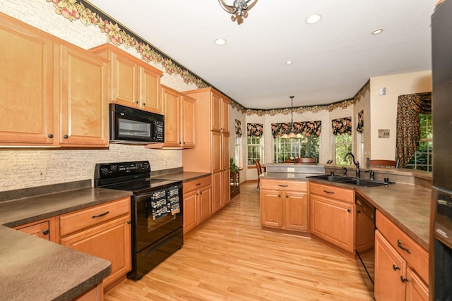 kitchen featuring light hardwood / wood-style flooring, black appliances, sink, decorative backsplash, and hanging light fixtures