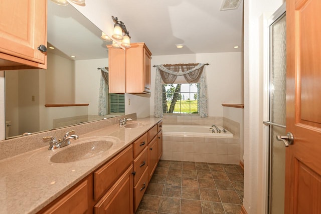 bathroom featuring vanity and a relaxing tiled tub