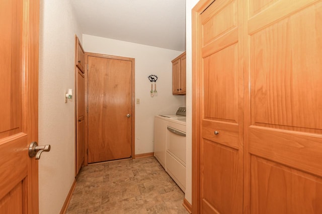 clothes washing area with washer and clothes dryer and cabinets