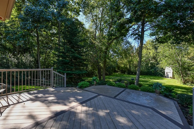 deck featuring a lawn and a storage unit