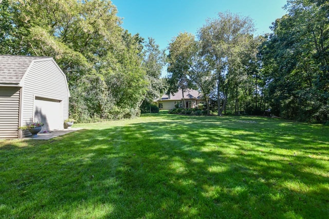 view of yard featuring an outdoor structure and a garage