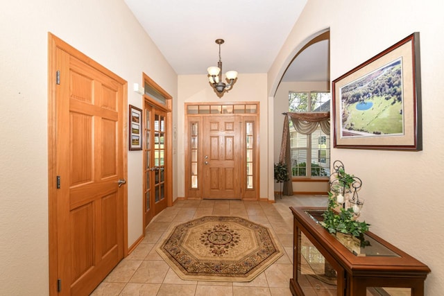 tiled entryway featuring an inviting chandelier