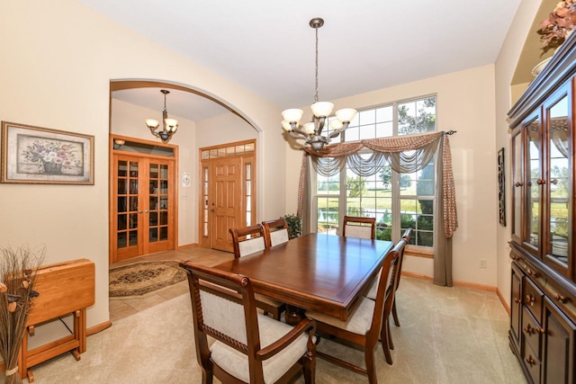 carpeted dining space featuring an inviting chandelier