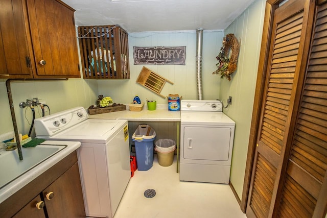 washroom featuring a sink, cabinet space, and washer and dryer