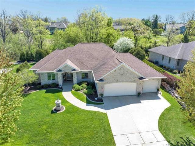 view of front of home with driveway, a front lawn, and an attached garage