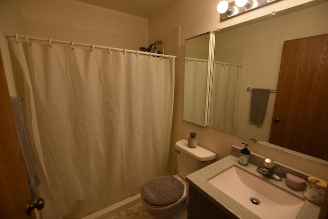 bathroom featuring toilet, vanity, and walk in shower