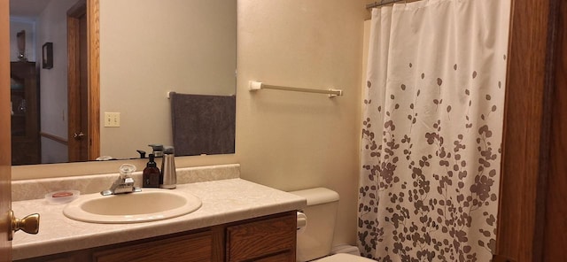 bathroom featuring a shower with shower curtain, toilet, and vanity