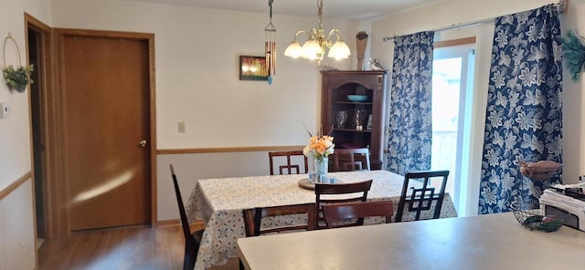 dining area featuring hardwood / wood-style flooring and a notable chandelier