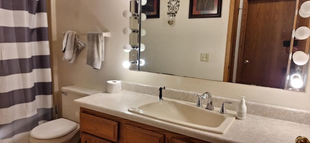 bathroom featuring vanity, toilet, and curtained shower