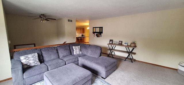 carpeted living room with ceiling fan