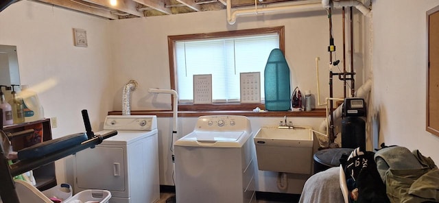 clothes washing area featuring independent washer and dryer and sink