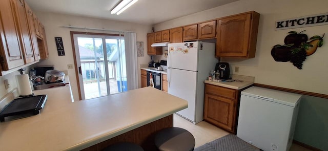 kitchen featuring kitchen peninsula, white fridge, refrigerator, and range with electric stovetop