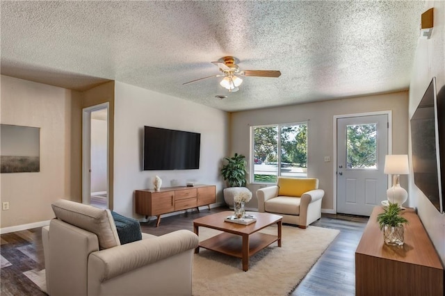 living room with ceiling fan, dark hardwood / wood-style flooring, and a textured ceiling