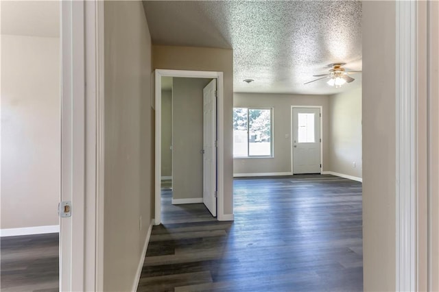 entryway featuring dark wood-type flooring, a textured ceiling, and ceiling fan