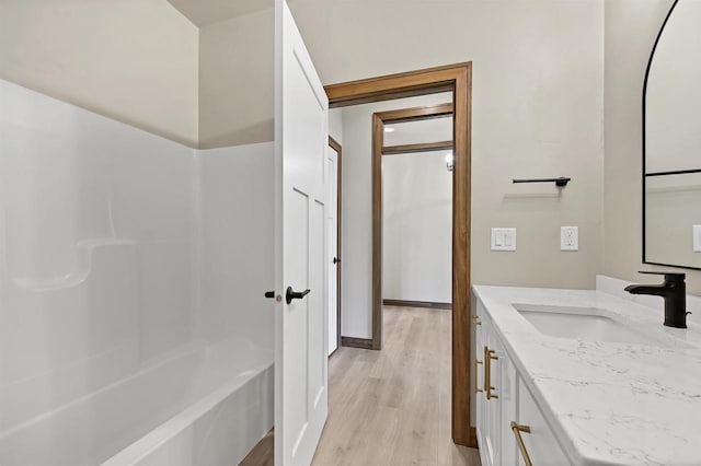 1630 N Honeysuckle Cir, De Pere, WI 54115 - bathroom featuring baseboards, bathing tub / shower combination, wood finished floors, and vanity