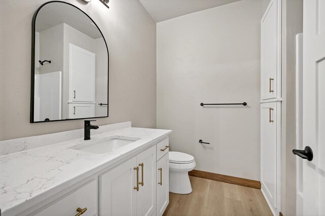 1630 N Honeysuckle Cir, De Pere, WI 54115 - bathroom featuring vanity, toilet, wood finished floors, and baseboards