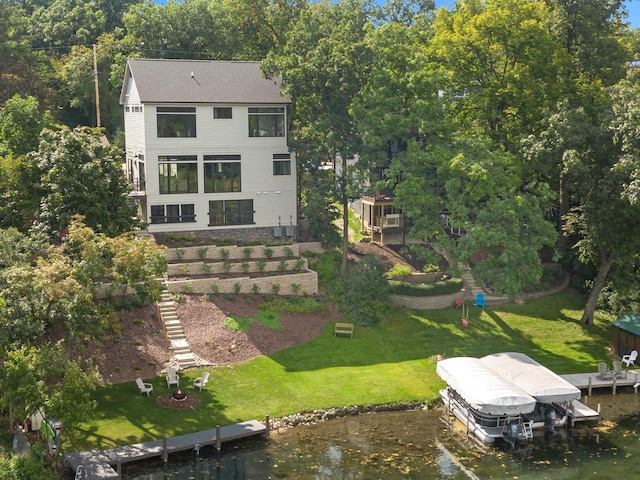 back of property featuring a water view and a lawn