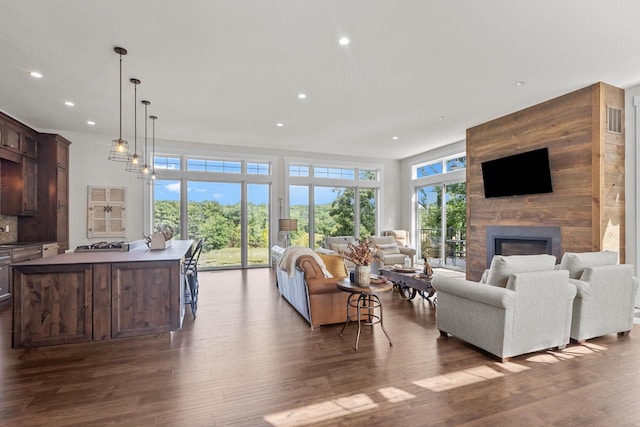 living room with dark hardwood / wood-style flooring and a large fireplace