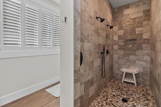 bathroom with hardwood / wood-style flooring and a tile shower