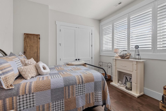 bedroom with dark wood-type flooring and a closet