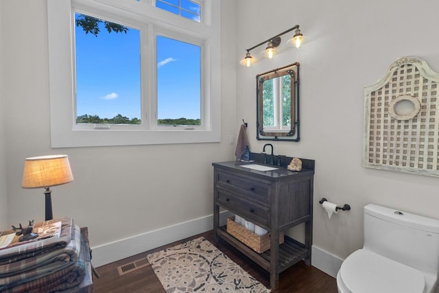 bathroom with vanity, toilet, and hardwood / wood-style flooring