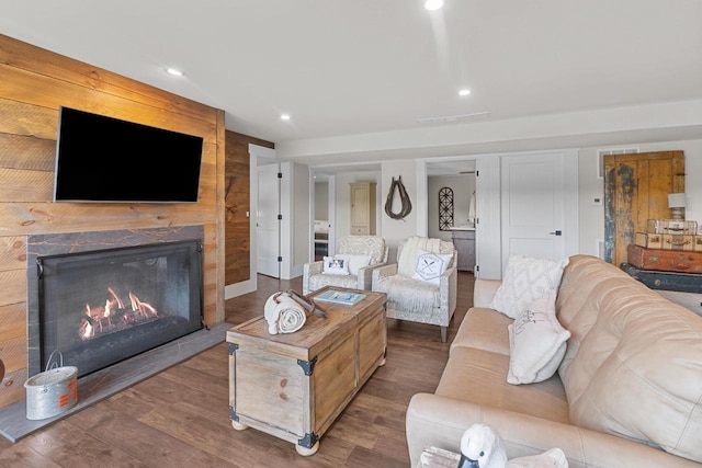 living room with a large fireplace and wood-type flooring