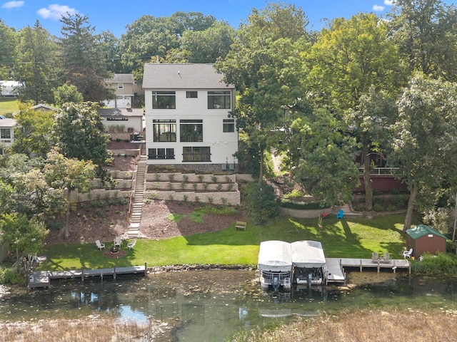 rear view of property with a water view and a shed