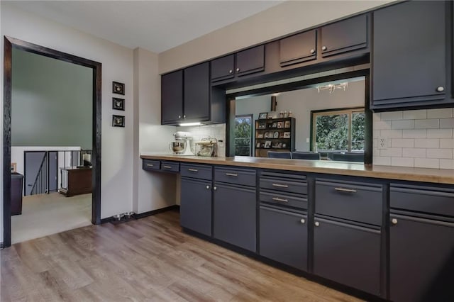 kitchen featuring decorative backsplash, gray cabinetry, light hardwood / wood-style floors, and butcher block counters