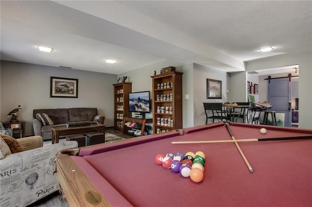 rec room featuring a textured ceiling, pool table, and a barn door