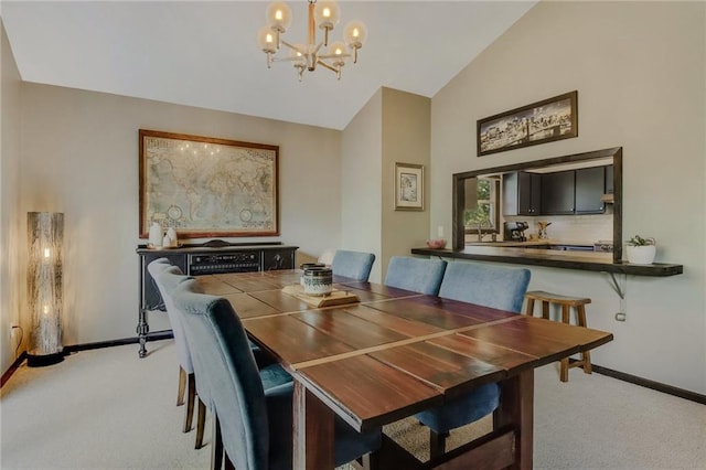 dining area with light carpet, a chandelier, and vaulted ceiling