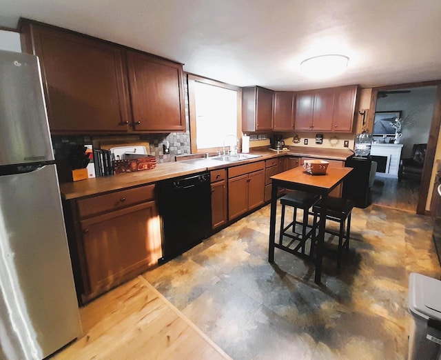 kitchen featuring stainless steel fridge, tasteful backsplash, black dishwasher, wooden counters, and sink