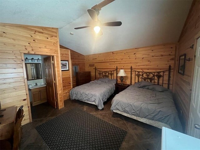 bedroom featuring a textured ceiling, vaulted ceiling, wood walls, connected bathroom, and ceiling fan