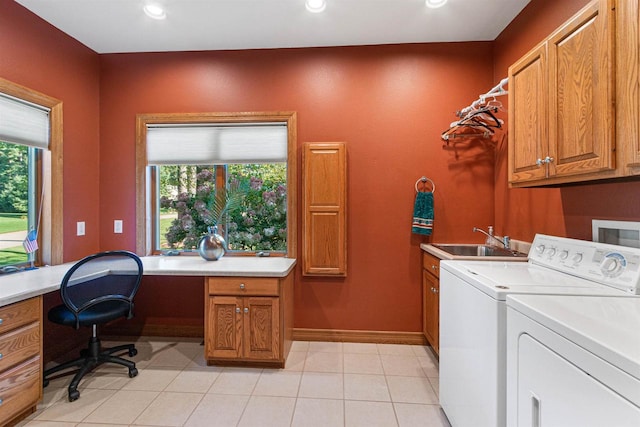 clothes washing area with a wealth of natural light, cabinets, sink, and independent washer and dryer