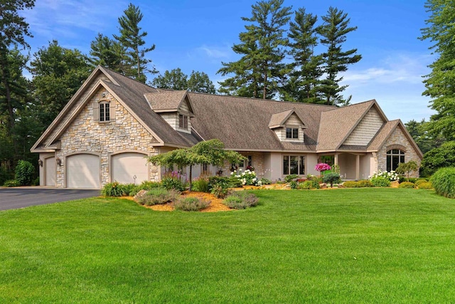 view of front of property featuring a garage, aphalt driveway, roof with shingles, and a front yard