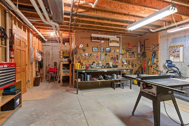 basement with a workshop area and electric panel