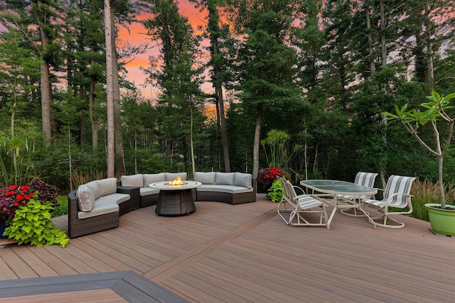 deck at dusk with an outdoor living space with a fire pit