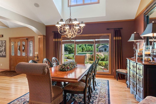 dining room featuring an inviting chandelier, plenty of natural light, light hardwood / wood-style floors, and vaulted ceiling