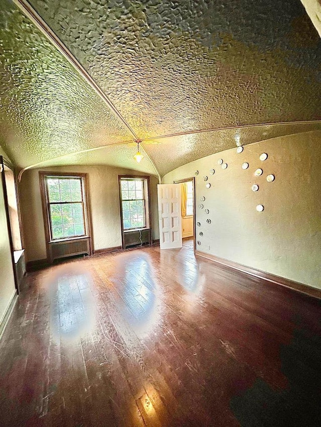 empty room featuring a textured ceiling and dark hardwood / wood-style flooring