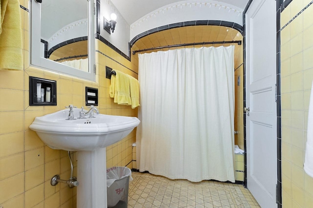 bathroom featuring tile patterned flooring, tile walls, and tasteful backsplash