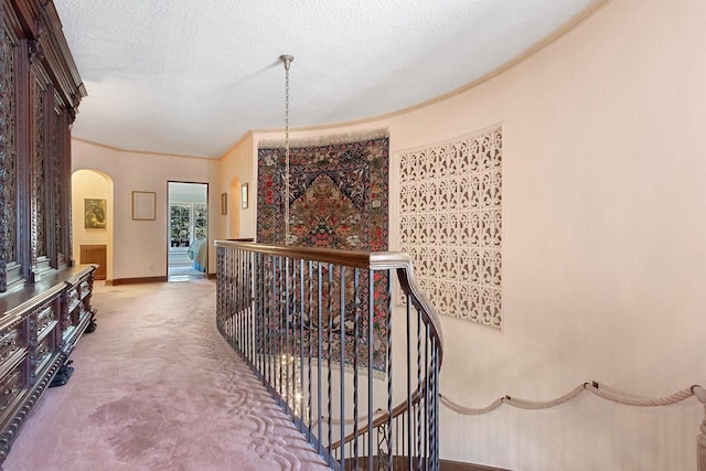 hall with a textured ceiling and carpet floors