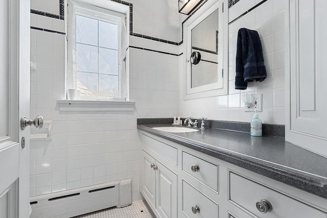 bathroom with vanity, tile walls, baseboard heating, and tile patterned flooring