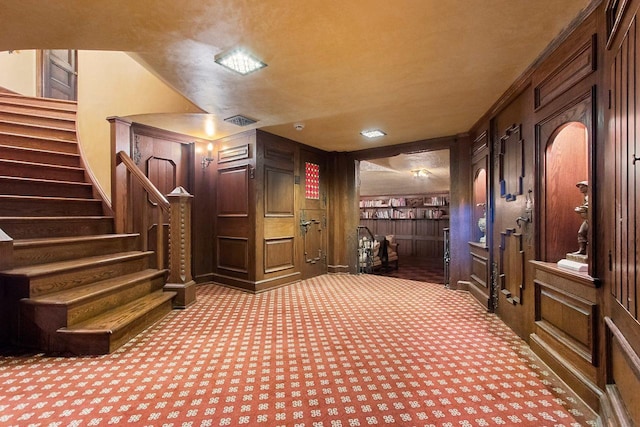 carpeted home theater room featuring wood walls