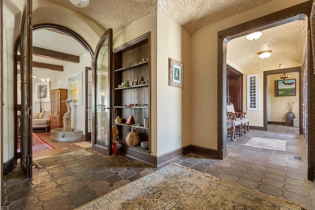 hallway featuring a textured ceiling and beamed ceiling