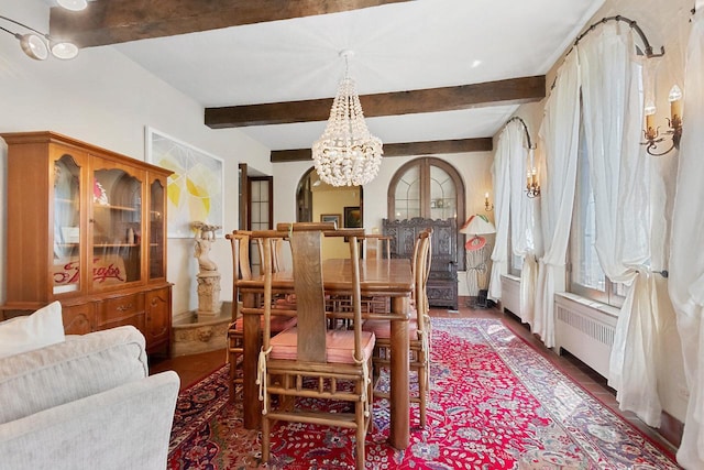 dining space with an inviting chandelier, radiator heating unit, and beam ceiling