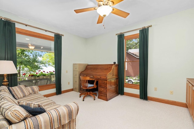 living area with light carpet and ceiling fan