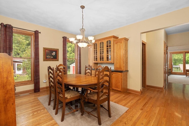 dining room with light hardwood / wood-style floors and a notable chandelier