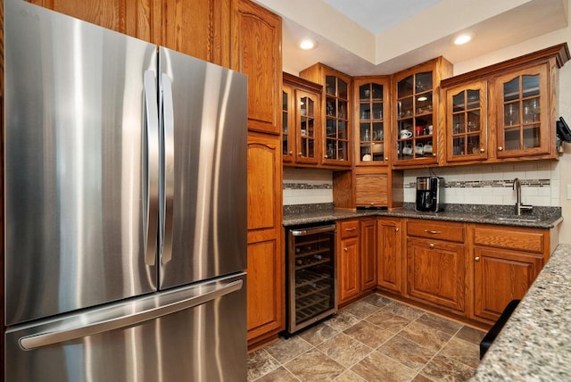 kitchen with stainless steel fridge, tasteful backsplash, beverage cooler, and dark stone countertops