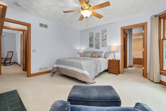 carpeted bedroom with ceiling fan and ensuite bath