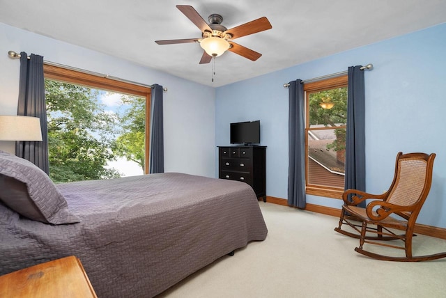 carpeted bedroom with multiple windows and ceiling fan