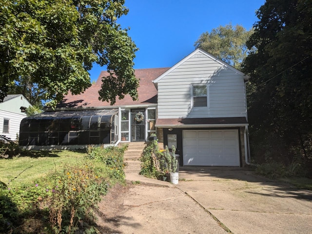 view of front facade with a garage and a sunroom